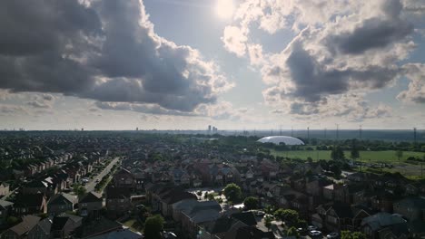una amplia toma de un drone de una ciudad suburbana, soleada y nublada, jibbing de alto a bajo