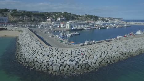 Orbitando-Alrededor-De-Una-Construcción-De-Rompeolas-En-Un-Pequeño-Muelle-Costero