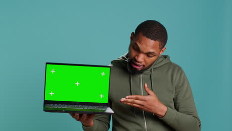 Man-holding-green-screen-laptop,-doing-recommendation