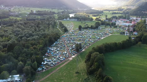 aerial drone shot of a camping ground at a music festival in a green and lush mountainous area