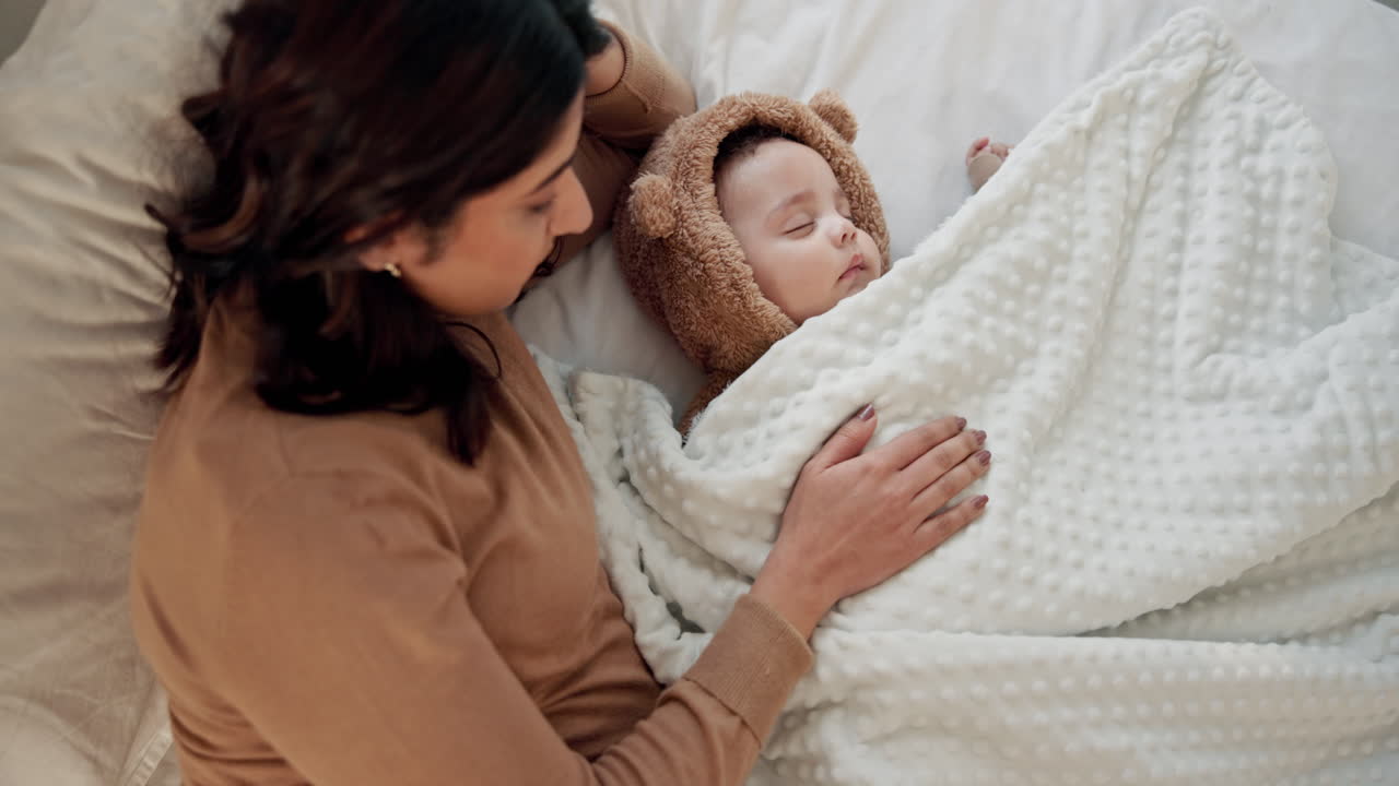 Una madre cocciola amorevolmente il suo bambino addormentato nel letto