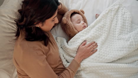 una madre acuna amorosamente a su bebé durmiente en la cama