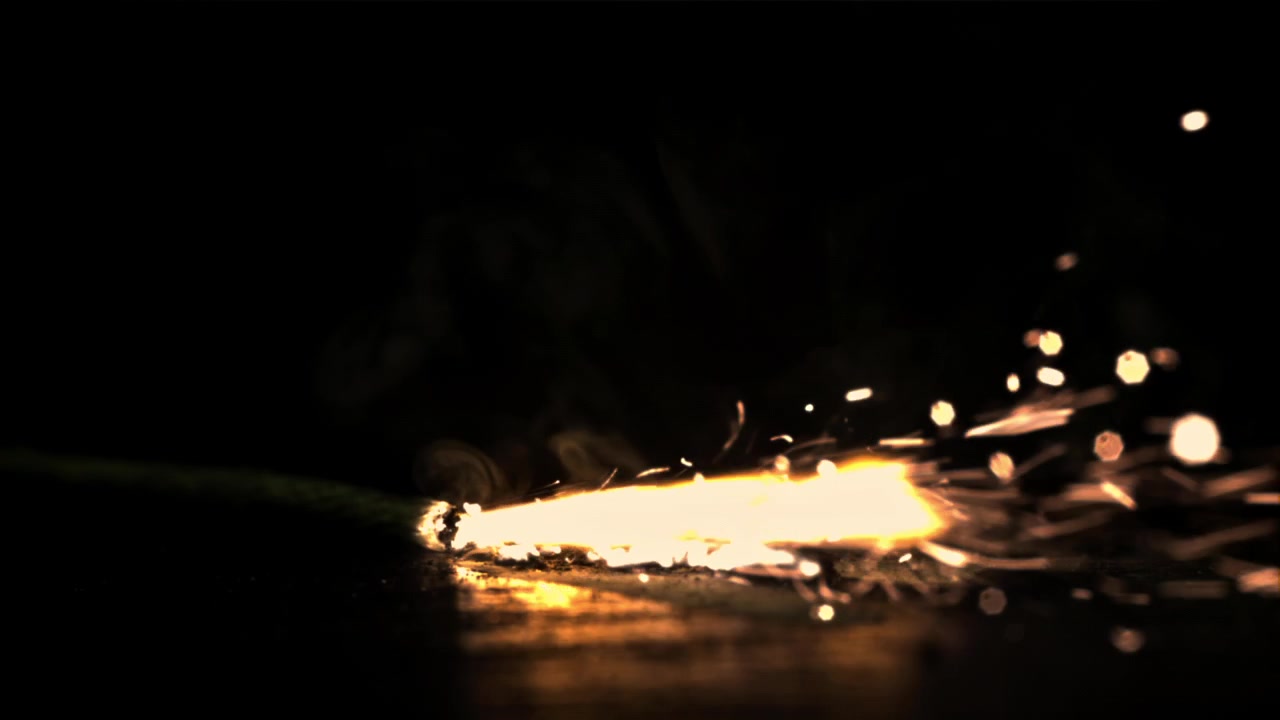 Miccia che brucia con scintille luminose al rallentatore su sfondo nero
