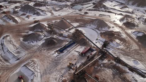 top down view of gravel pit with driving truck and heavy mining machinery - dolly in shot