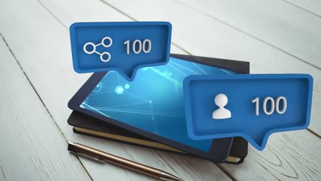 un tablet su un notebook e una bolla di messaggi con icone per i social media