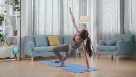 joven atleta asiática haciendo ejercicio, estirándose y practicando yoga en casa. estilo de vida saludable, fitness, bienestar y concepto de atención plena