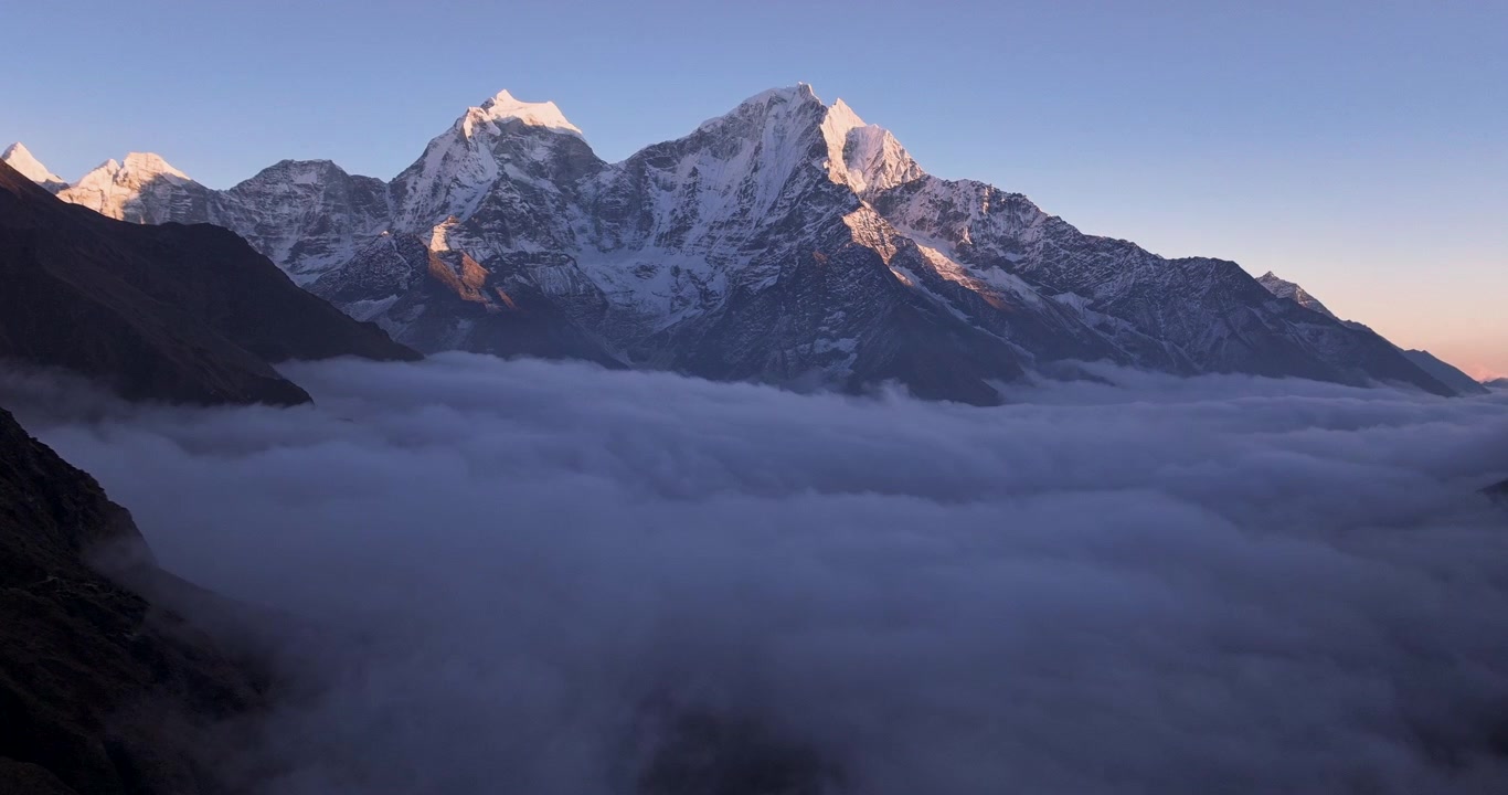 Phortse landsby, Everest, Nepal, aftensolnedgang hyperlapse-optagelse af et tæt hvidt skydække, der bølger og hopper under de sneklædte tinder af Thamserku- og Kangtega-bjergene.