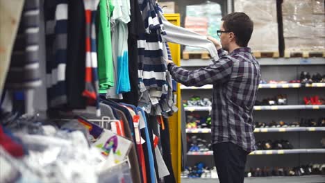 hombre comprando ropa en una tienda de ropa