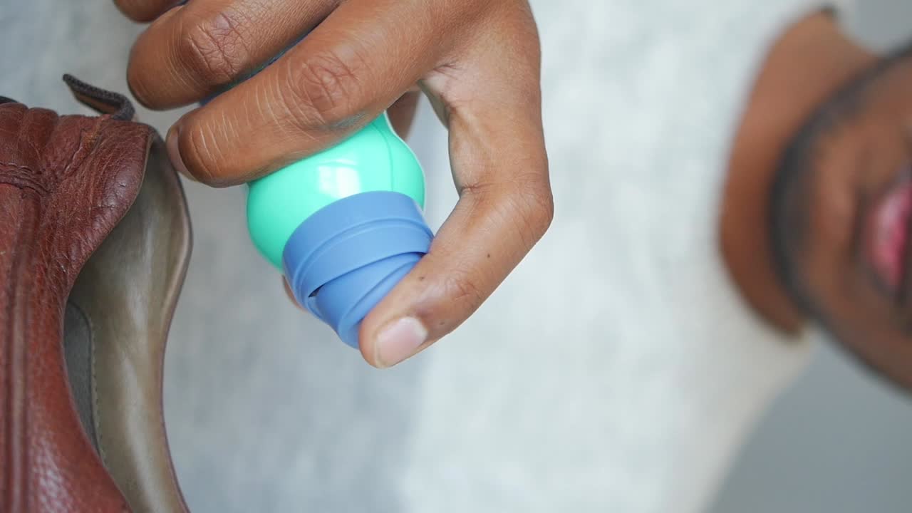 Close-up of a hand applying a product to a shoe