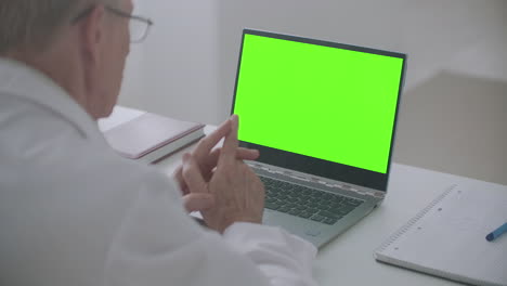 la pantalla de la llave de croma de la computadora portátil los médicos masculinos están usando llamada de video