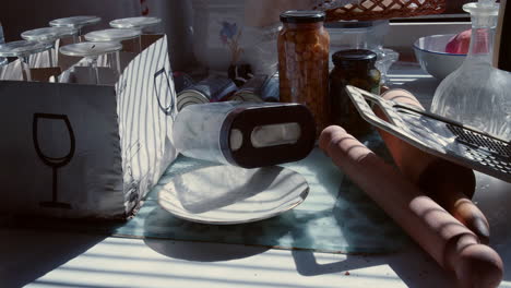 the slow panning of the camera reveals the mess on the kitchen counter in the morning sun