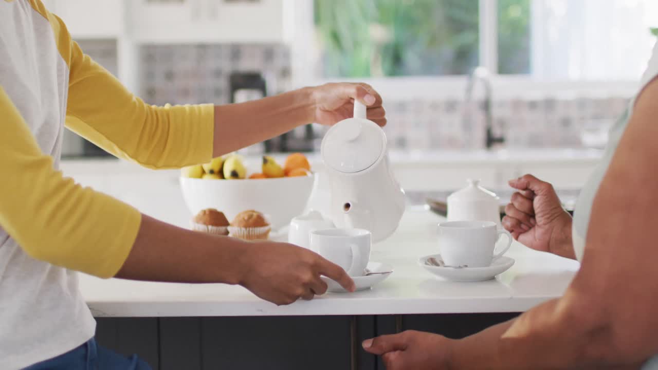 счастливая старшая афроамериканка разговаривает с взрослой дочерью дома