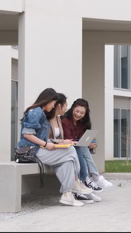 three asian girl students using the laptop at break time sitting on campus