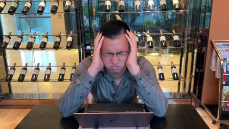 stressed asian millennial entrepreneur man showing stress and frustration while working on laptop