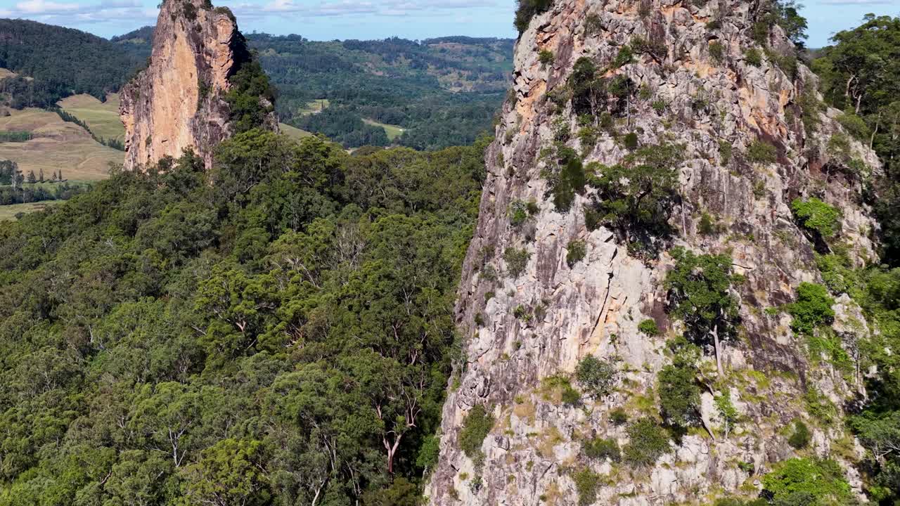Aerial footage of Nimbin Rocks, showcasing rugged cliffs and lush greenery under bright daylight