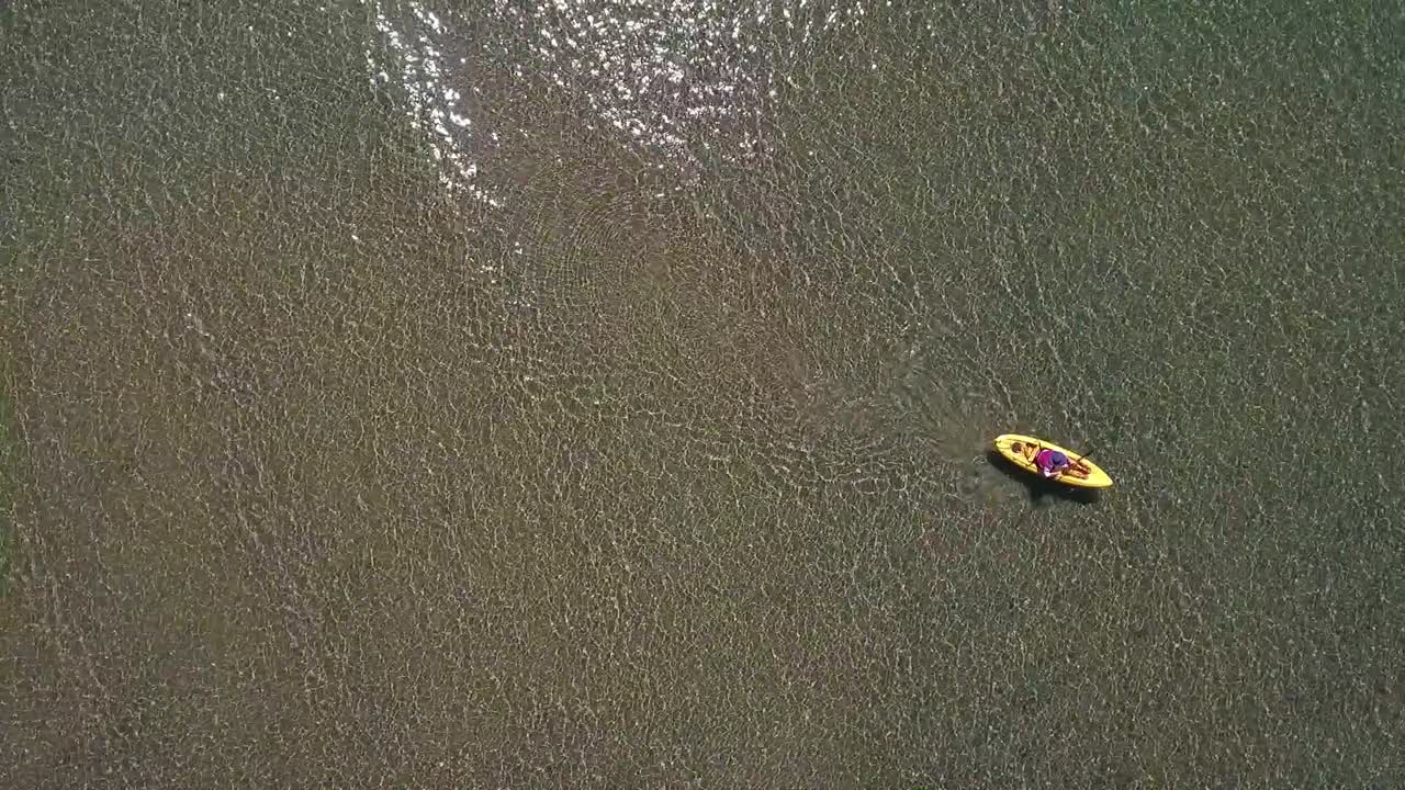 una mujer en un kayak amarillo rema a la luz del sol en el agua cristalina del lago tahoe en un brillante día de verano 2