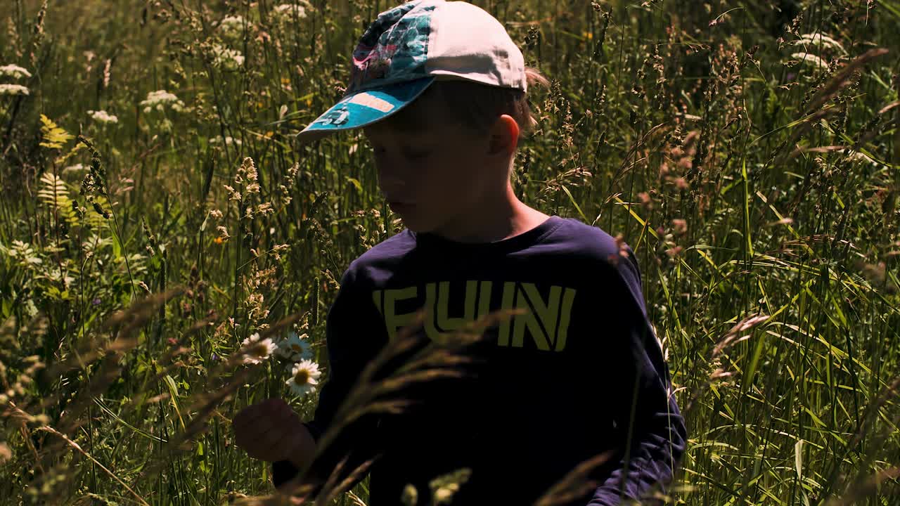 Gutt på en eng med blomster