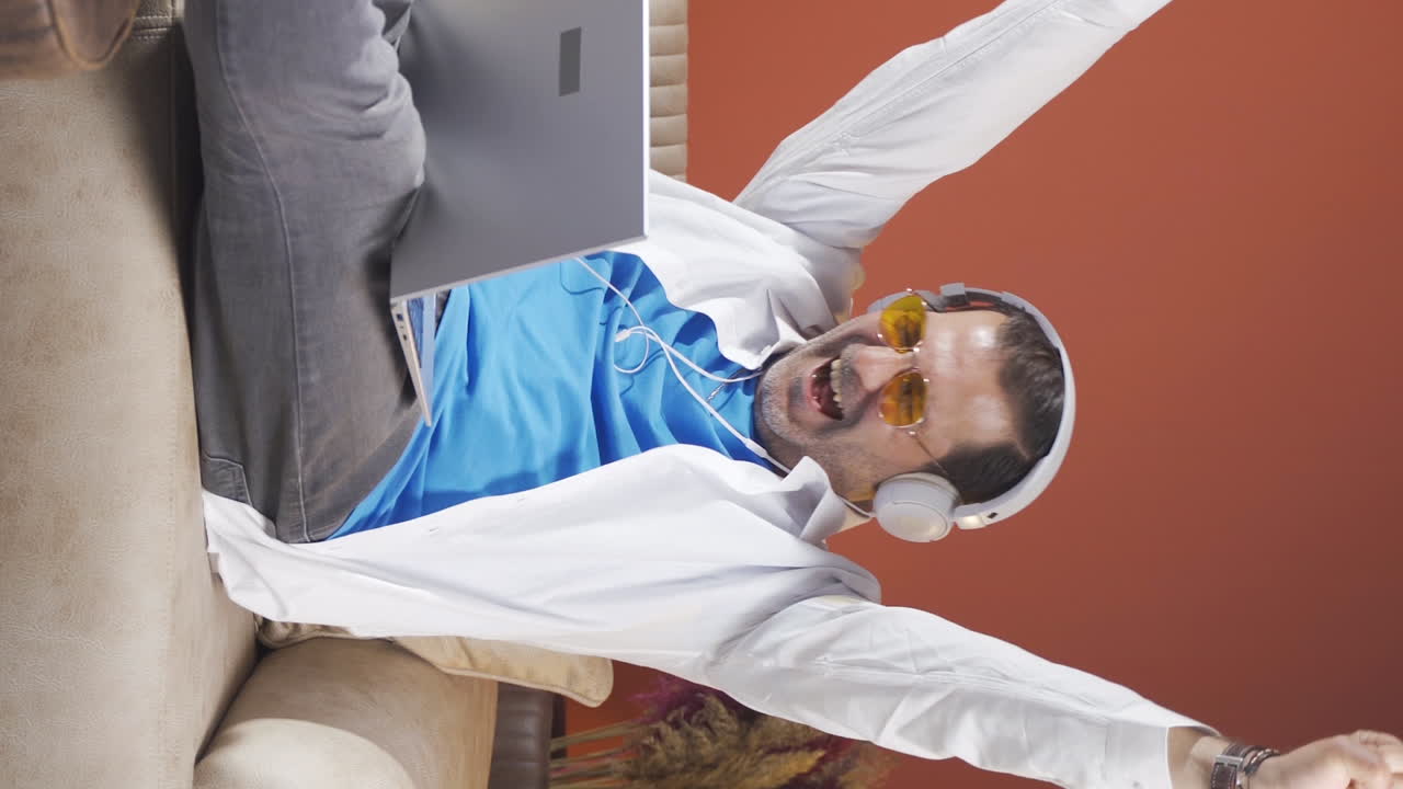 남자가 노트북을 보고 기 ⁇ 하는 수직 비디오입니다.