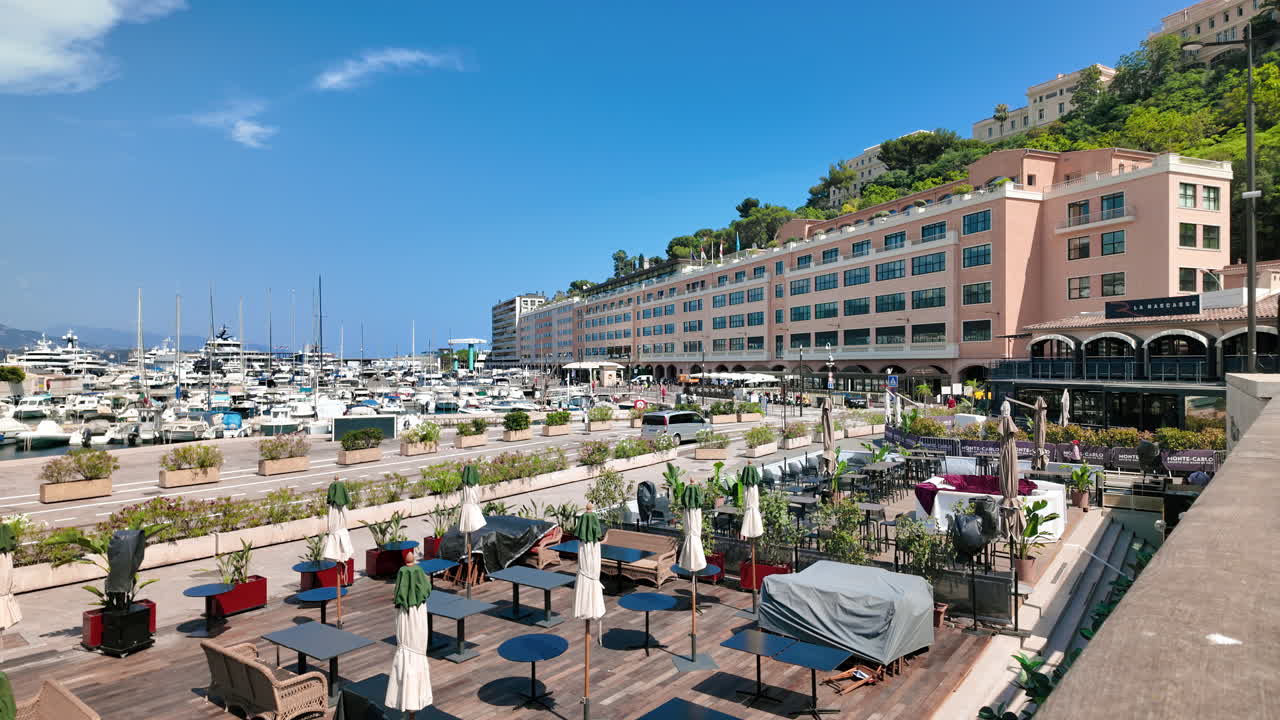 View of white boats docked in the Monaco Marina with the skyline on the background
