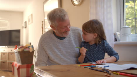 abuelo y nieta coloreando imágenes juntos