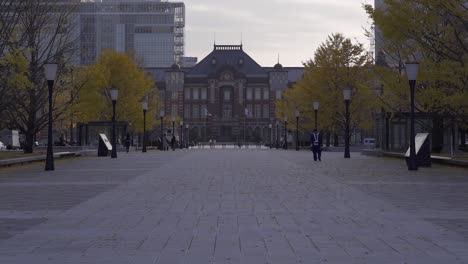 slow tilt up towards tokyo station with few people during early morning