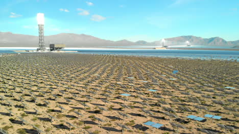 low aerial slide of solar electric generators in desert