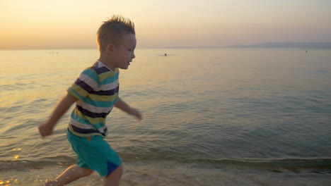 Lächelnder-Junge,-Der-Am-Meer-Entlang-Läuft