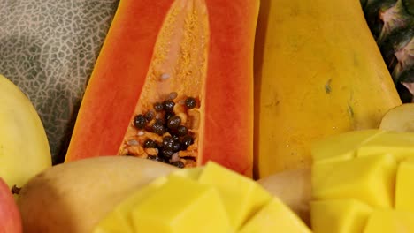 a vibrant display of sliced papaya, mango, and cantaloupe showcasing a colorful tropical fruit arrangement.