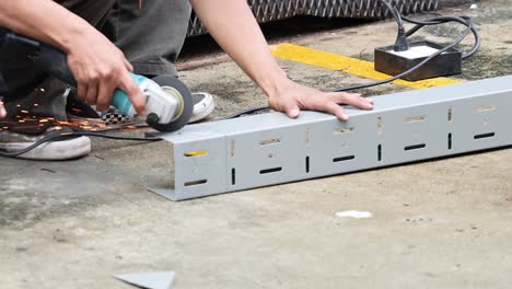 worker using grinder to cut metal piece