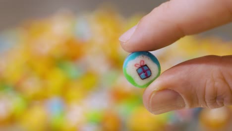 hand holding colorful candy with a gift on it