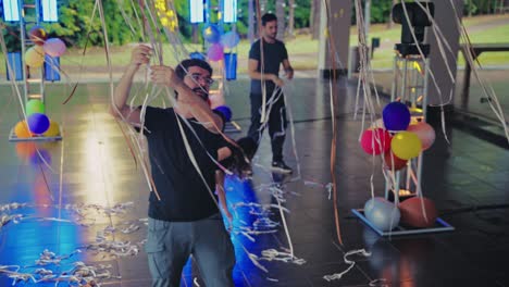 people preparing an event space with festive streamers and balloons