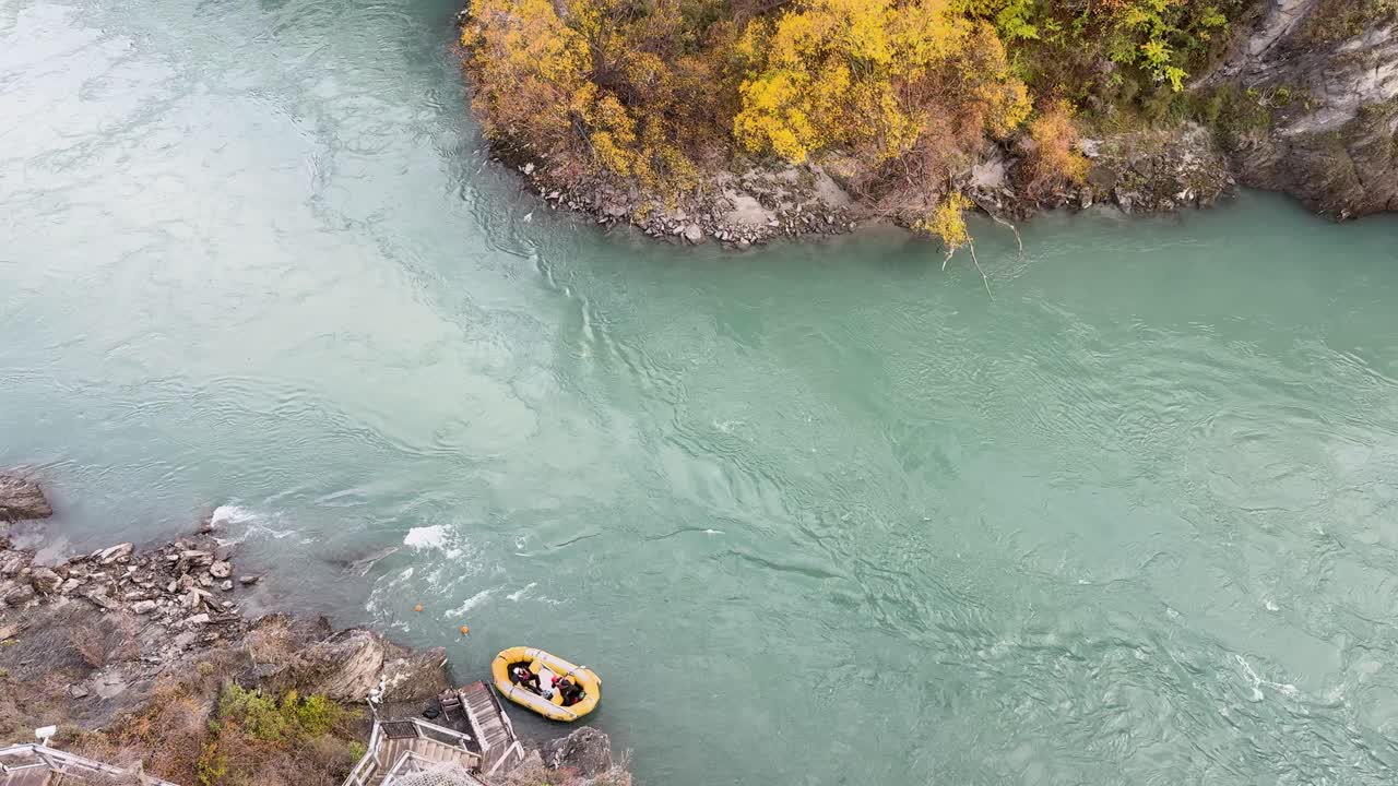 A thrilling bungy jump over a turquoise river surrounded by autumn foliage in Queenstown, New Zealand