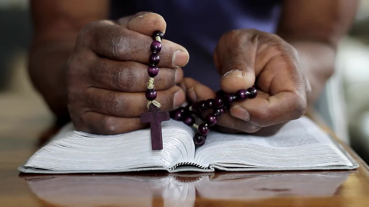 hombre orando a dios con la mano en la biblia con la gente stock video stock footage