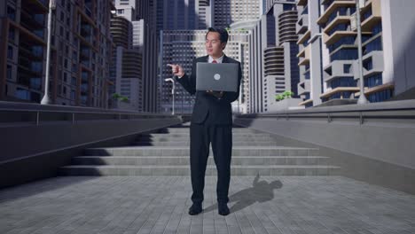 full body of asian business man smiling while using laptop computer and pointing to the side in city
