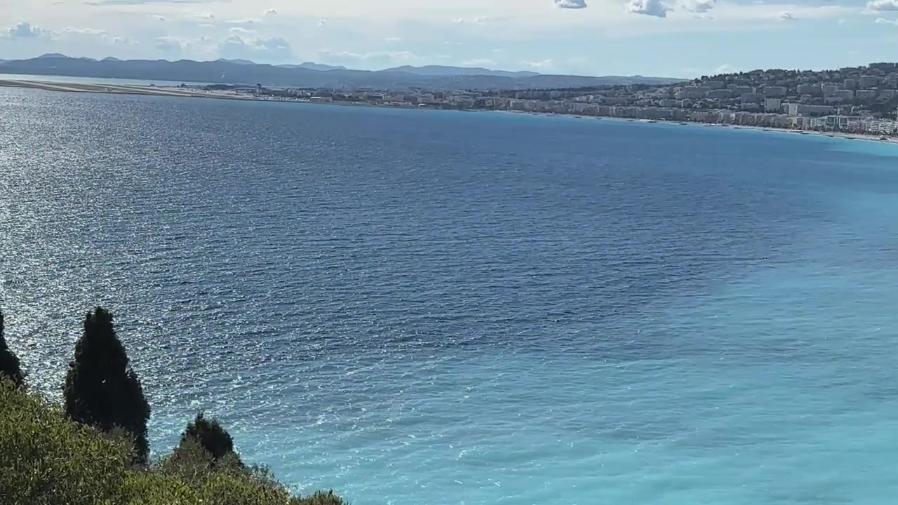 Vue panoramique sur les eaux bleues de la Méditerranée de la Baie des Anges, vers le littoral de Nice et les montagnes lointaines depuis la Colline du Château