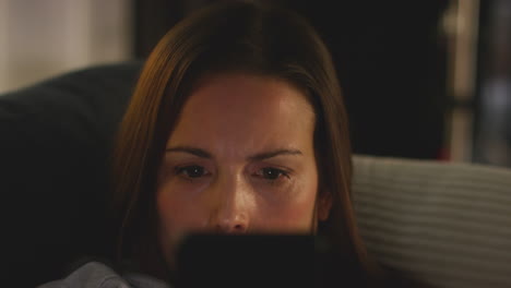 Close-Up-Of-Anxious-Woman-Sitting-On-Sofa-At-Home-At-Night-Looking-At-Mobile-Phone-Concerned-About-Social-Media-Or-Bad-News-1