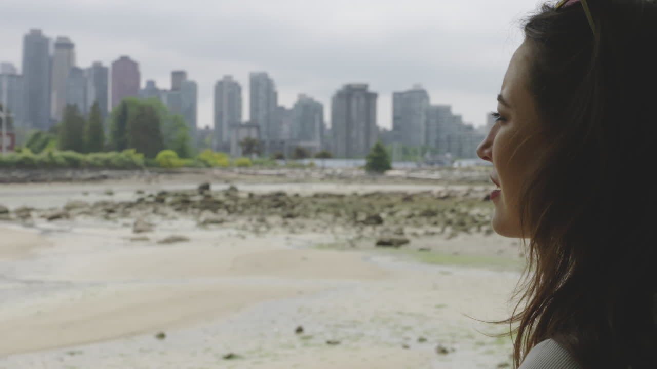 mujer joven y atractiva que disfruta de la vista del hermoso horizonte de la ciudad de vancouver