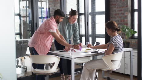 Three-business-professionals-are-engaged-in-a-collaborative-work-session-at-a-bright-office