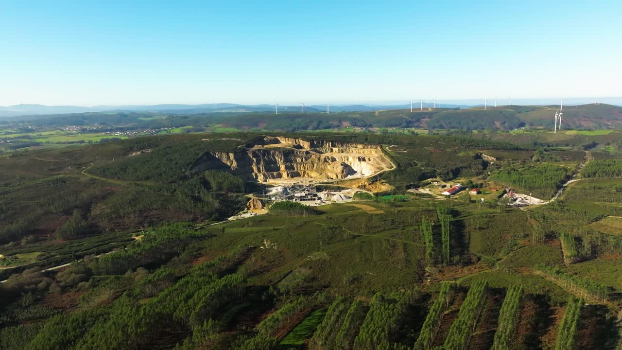 Pedreira com turbinas eólicas ao fundo gerando energia limpa perto de Castriz em A Coruña, Espanha