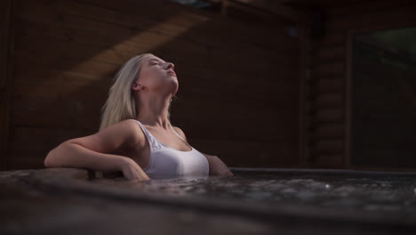 mujer joven disfrutando del jacuzzi al aire libre