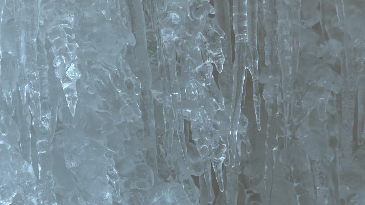 Detailed close up view of layered, textured and jagged icicles inside the Eben Ice Caves in Michigan, USA