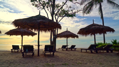 umbrella and chair on tropical beach with sunrise in morning