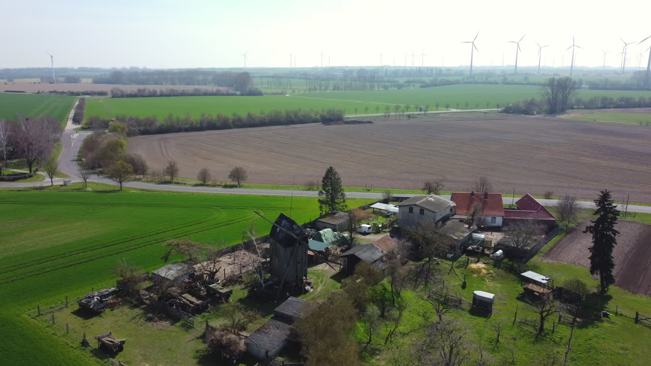 Aerial View of a Farm with a Historic Windmill and Surrounding Fields