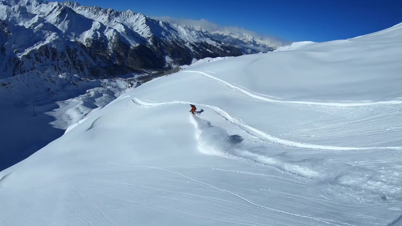 Timelapse showing freeriders carving fresh lines across deep powder in the Tortin sector of Verbier, the iconic freeride face gradually filling with tracks as skiers descend.