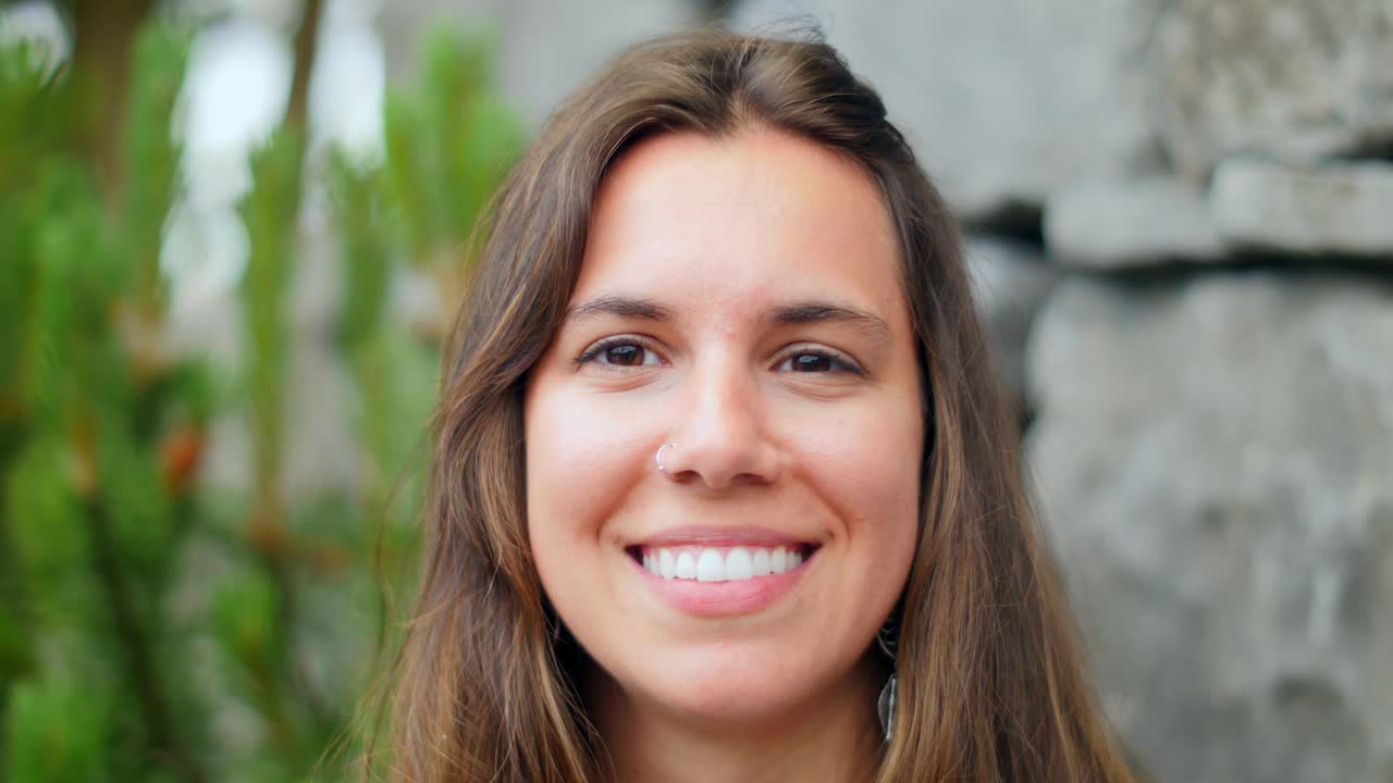 joven y hermosa mujer sonríe directamente a la cámara, su cautivadora mirada atrae al espectador, evocando alegría y serenidad