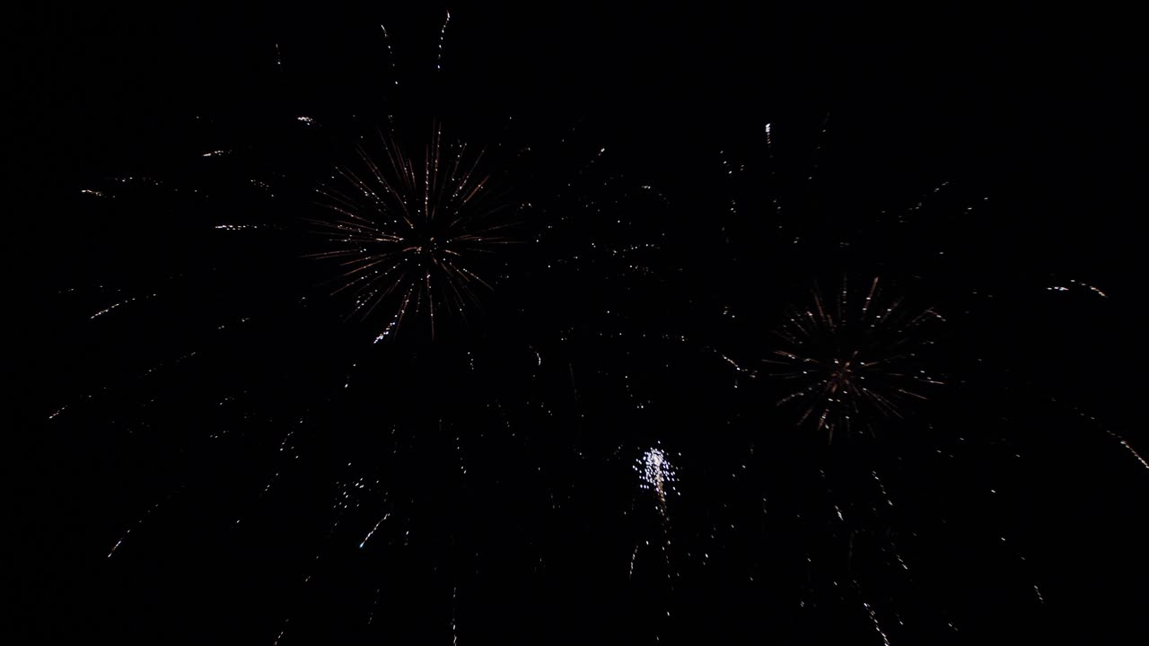 Slowmotion gimbal tilting shot of a beautiful of a firework show at night