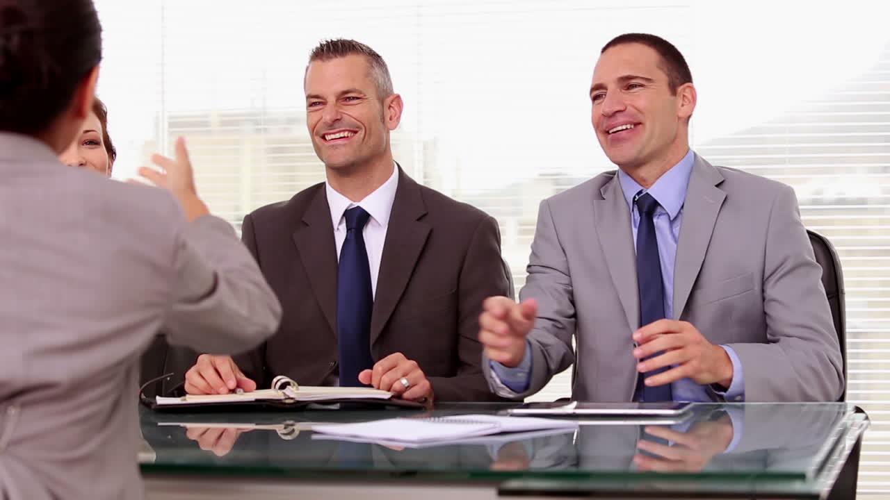 취업 신청자가 사업가들의 손을 흔들고 있습니다.