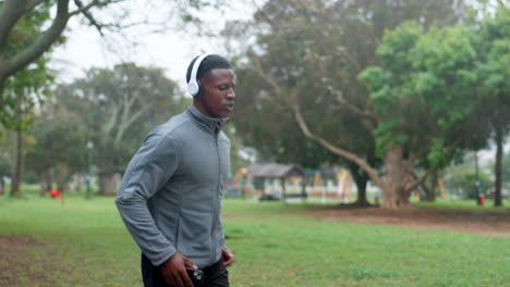 man jogging in a park listening to music on his phone