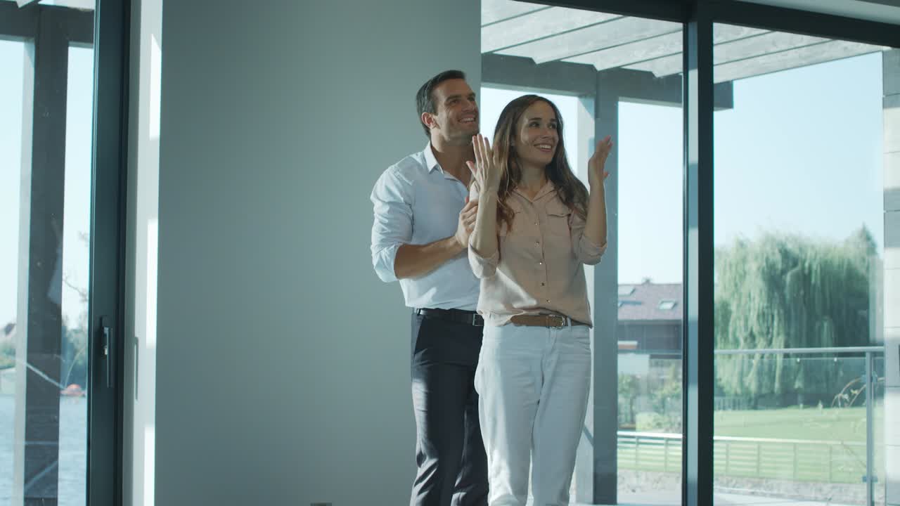 Hombre contento tapando los ojos a mujer en casa nueva. Esposa feliz disfrutando de una casa de lujo.