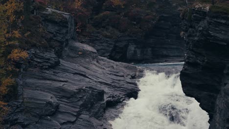 cascade flowing through rocky cliff of mountain in the forest